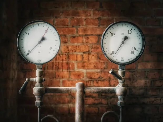 Zwei Manometer an einer Leitung vor Ziegelwand