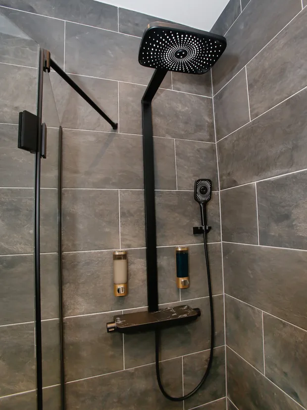 Schwarze Regendusche mit Thermostatarmatur in der Eckdusche