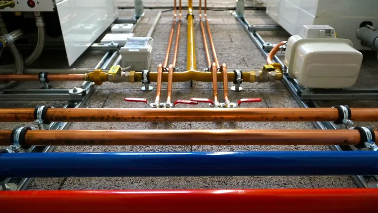 Farbig gekennzeichnete Heizungs- und Wasserleitungen im Technikraum