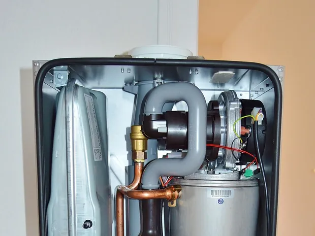 Geoeffnete Gastherme mit Blick auf Pumpe und Waermetauscher